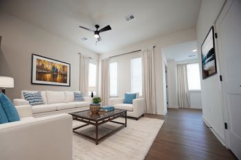 Living room with ceiling fan and wood-style flooring at West Row Lofts and Townhomes in Birmingham, AL